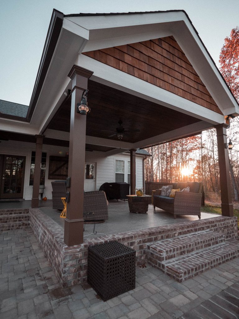Concrete back porch photo in Atlanta with a roof extension by Post & Oak Design + Build | Outdoor Photos | Porch | Landscaping | Landscape Design | Outdoor Living Space | Porch Design Ideas | Outdoor Living Space Ideas | Backyard Design