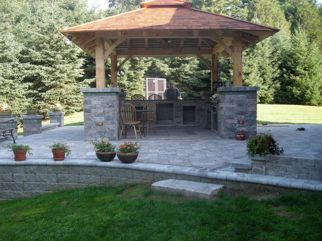 Concrete paver patio kitchen photo in Bridgeport with a pergola