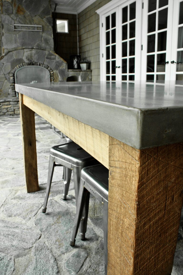 Concrete tabletop sitting on a reclaimed barnwood table base. Indoor/outdoor