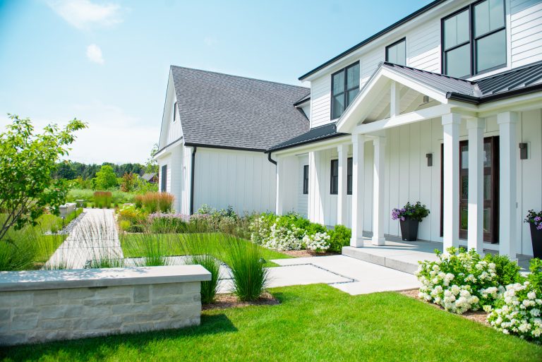 Concrete was chosen for all the paved areas for a modern aesthetic. Natural stone garden walls were designed to frame the front entry and landscaping. Renn Kuennen Photography by Ginkgo Leaf Studio | Outdoor Photos | Porch | Landscaping | Landscape Design | Outdoor Living Space | Porch Design Ideas | Outdoor Living Space Ideas | Backyard Design