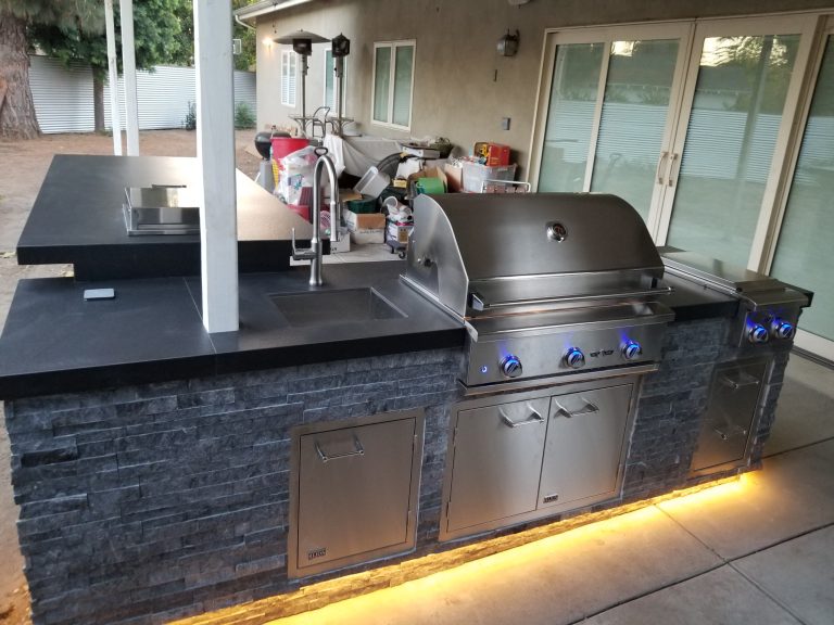 Contemporary L-shape Island with Delta Heat grill and raised bar with a pop-up outlet