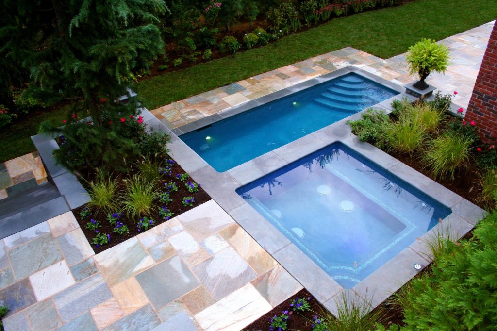 Contemporary Pool and Spa design & installation in Bergen County, Northern NJ. This sleek pool installation has a custom glass water wall with a raised spa. Perfect for relaxation! by Cipriano Landscape Design & Custom Swimming Pools | Pool design | Pool Contracting | Swimming Pool Ideas | Swimming Pool Design Ideas