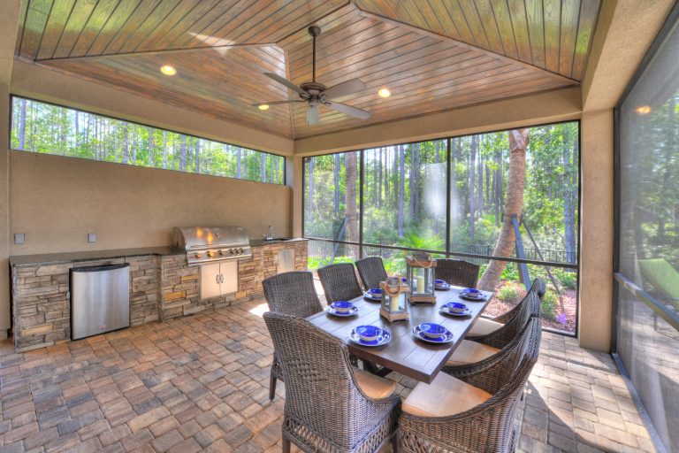 Cover lanai with full summer kitchen with dining area overlooking the pool. Photography: Tony Giese Inc.