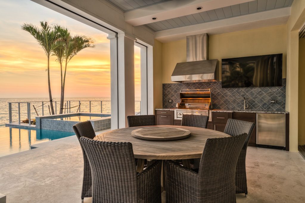 Covered Lanai with Outdoor Kitchen, power screens and shutters, off the pool deck.