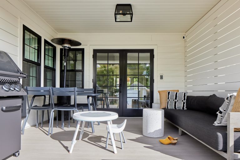 Covered back porch with white slat privacy wall.