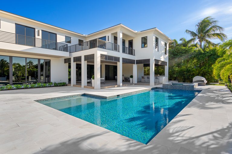 Covered outdoor living space and summer kitchen and pool with hot tub.