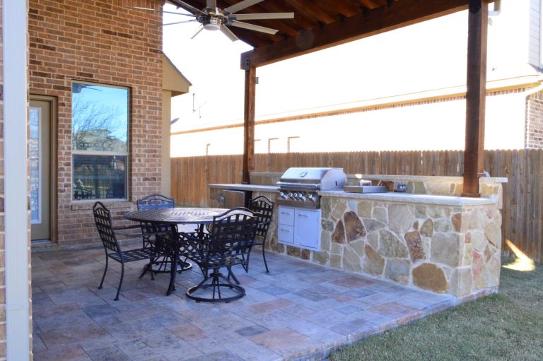 Custom Fort Worth TX outdoor kitchen with stain and stamp patio and pergola roof.