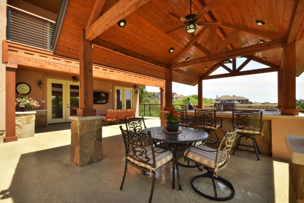 Custom outdoor kitchen, sitting area, and solid roof cabana by Southern Landscape. The entire project was constructed by leveling a severe slope with a concrete block retaining wall.