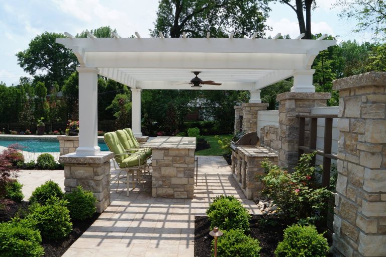 Custom pergola over outdoor kitchen with bar seating.