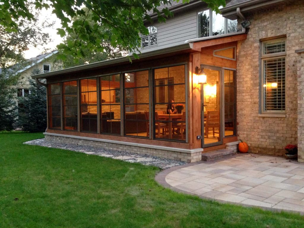 Custom screen porch features a cozy stone fireplace, cathedral ceilings, and vinyl 4-track windows.