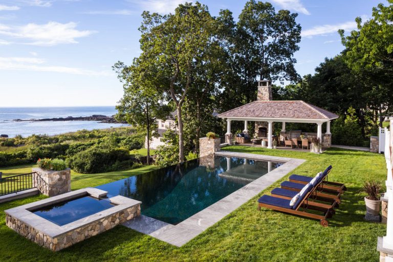 Custom stone outdoor pool patio, hot tub, outdoor kitchen, staircase, walkways, patio and gardens. High end outdoor living on the southern coast of Maine.