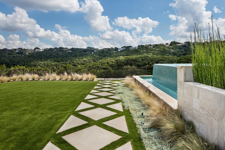 Cut stone pavers form an interesting pathway around the pool. Synthetic turf lawn provides an open space for kids to play and run around on.

Photo by Rachel Paul Photography by Double B Design, LLC | Backyard Design | Outdoor Living Spaces | Landscape Design | Backyard Ideas | Landscaping | Landscaping Ideas | Landscape Installation