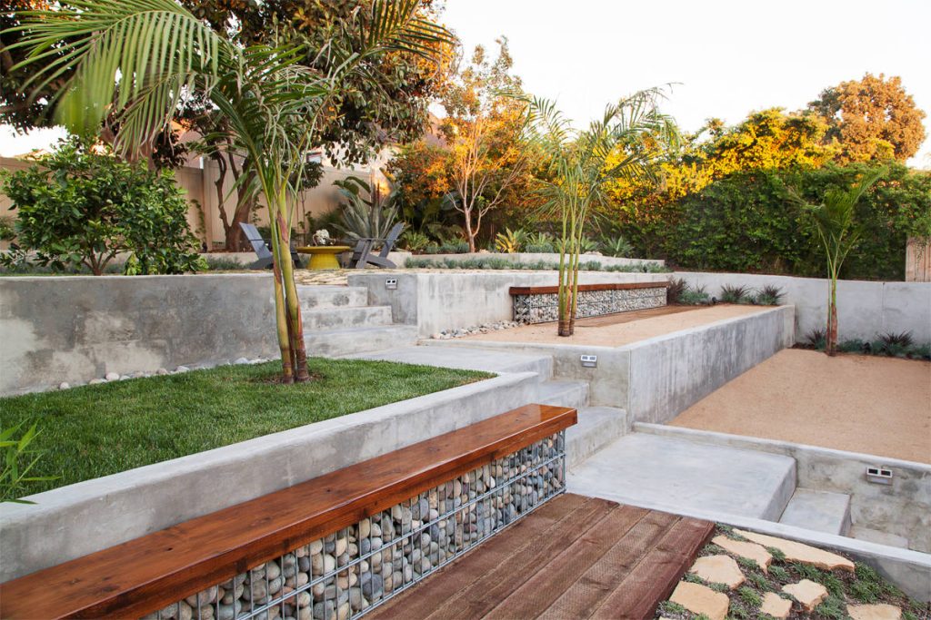 Design ideas for a contemporary partial sun backyard gravel retaining wall landscape in Los Angeles.