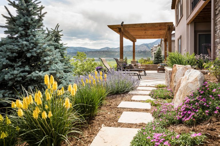 Design ideas for a mid-sized traditional full sun and drought-tolerant backyard stone landscaping in Denver for summer.