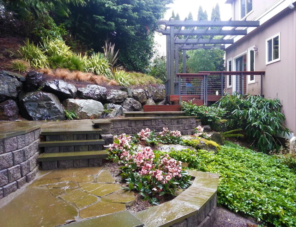 Design ideas for a mid-sized transitional shade backyard stone retaining wall landscape in Seattle.