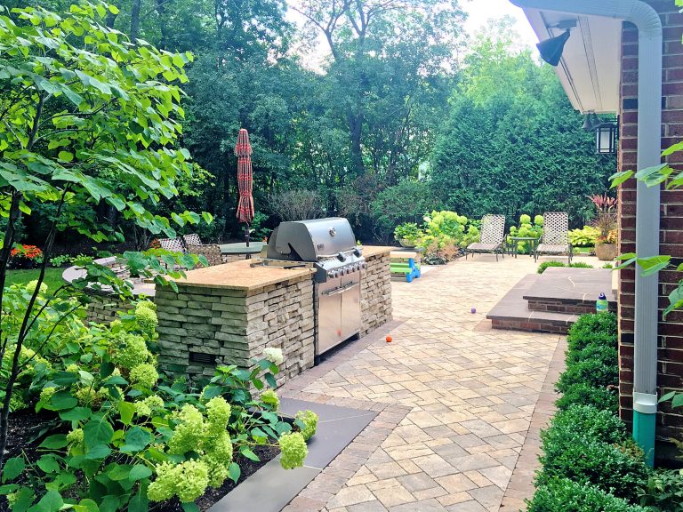 Designed and Built by: Arrow. Land + Structures. Professional Landscape Architects, Designers, and Builders. Elegant backyard concrete paver patio kitchen photo in Chicago with no cover by Arrow. Land + Structures | Outdoor Kitchens | Backyard Design | Outdoor Living Spaces | Landscape Design