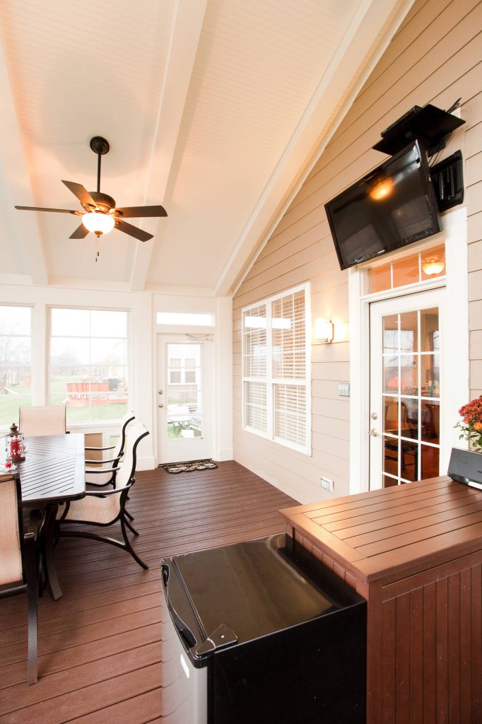 Easy access into the house and the outdoors, as well as an out-of-the way space for the TV add to the functionality of this 3-season porch addition.