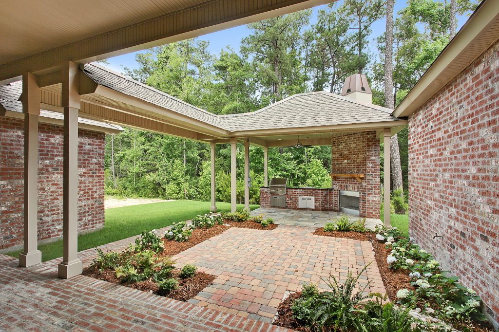 Elegant brick porch photo in New Orleans with a roof extension by Ron Lee Homes | Outdoor Photos | Porch | Landscaping | Landscape Design | Outdoor Living Space | Porch Design Ideas | Outdoor Living Space Ideas | Backyard Design