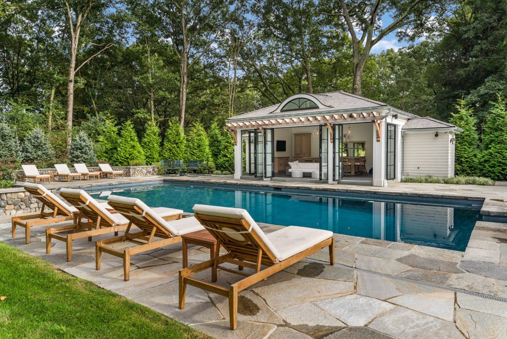 Elegant stone and rectangular pool house photo in New York