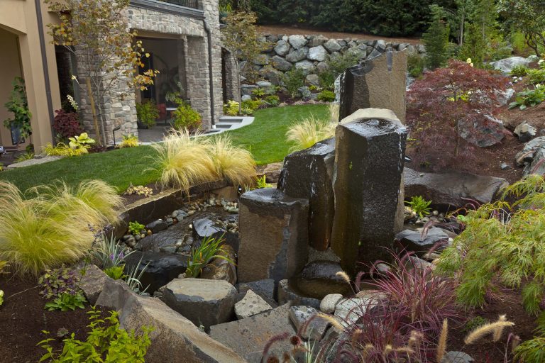 Elegant water feature surrounded by ornamental trees and grasses welcome visitors to the Bellevue home. Designed by Environmental Construction, Kirkland, WA
