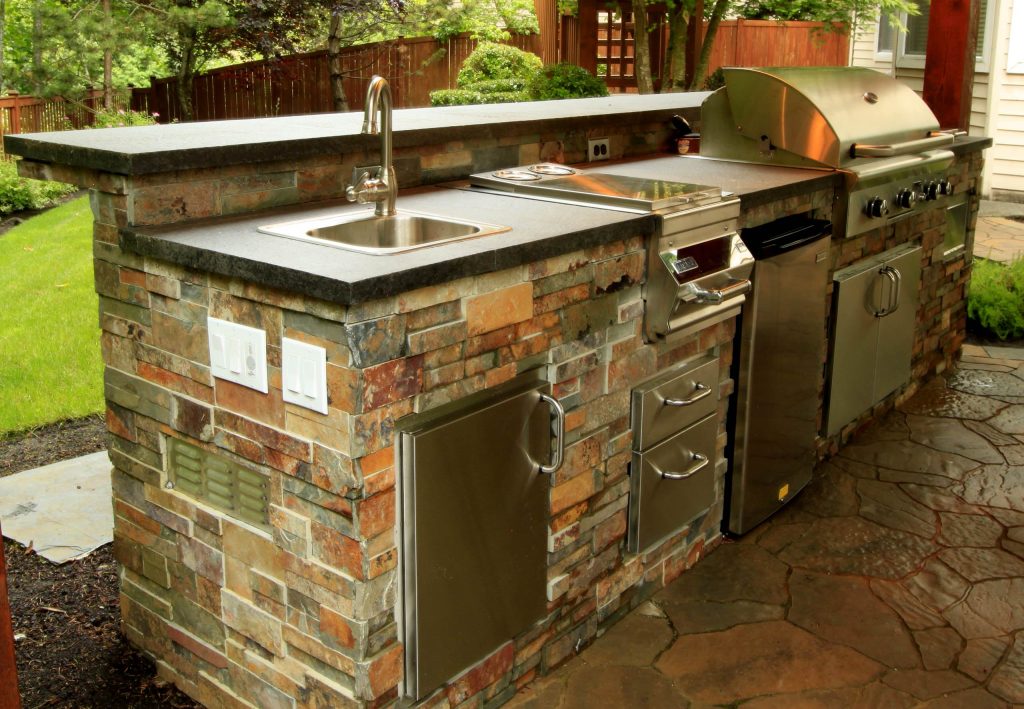 Example of a backyard brick patio kitchen design in Seattle