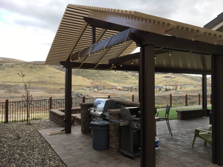 Example of a classic backyard brick patio kitchen design in Other with a pergola