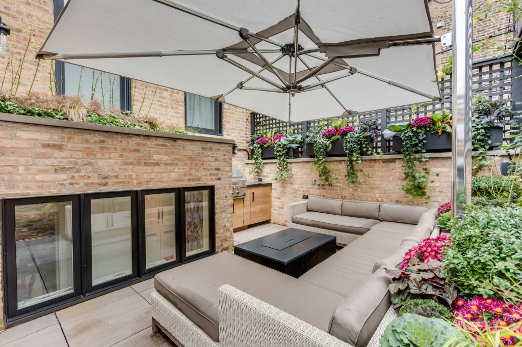 Example of a classic backyard patio kitchen design in Chicago with an awning