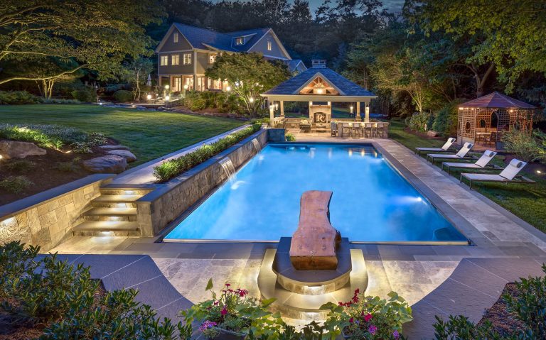 Example of a classic backyard stone and rectangular pool fountain design in Richmond