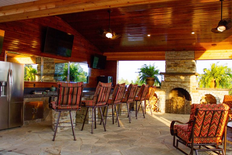 Example of a classic stone patio kitchen design in Huntington with a roof extension