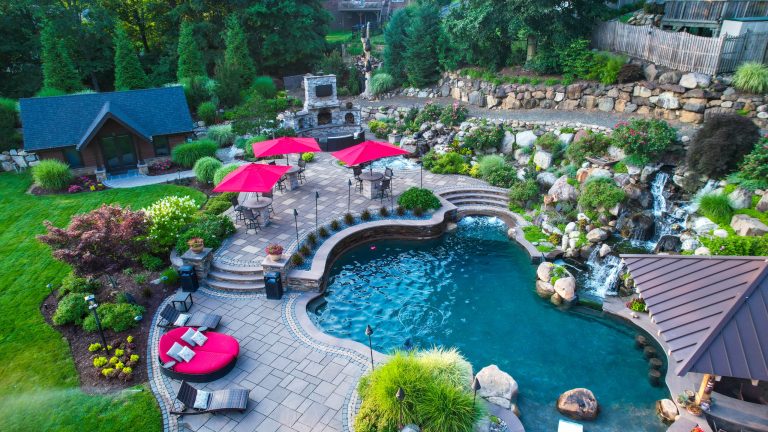 Example of a huge backyard stone patio kitchen design in New York with no cover