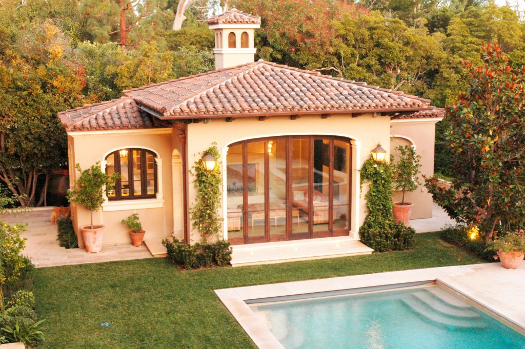 Example of a huge classic backyard stone and rectangular lap pool house design in Los Angeles