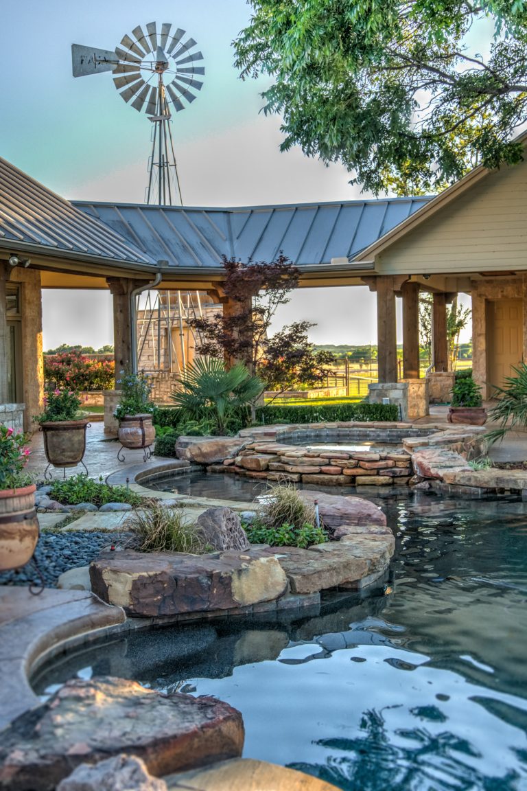 Example of a huge island style backyard stone and custom-shaped natural hot tub design in Austin
