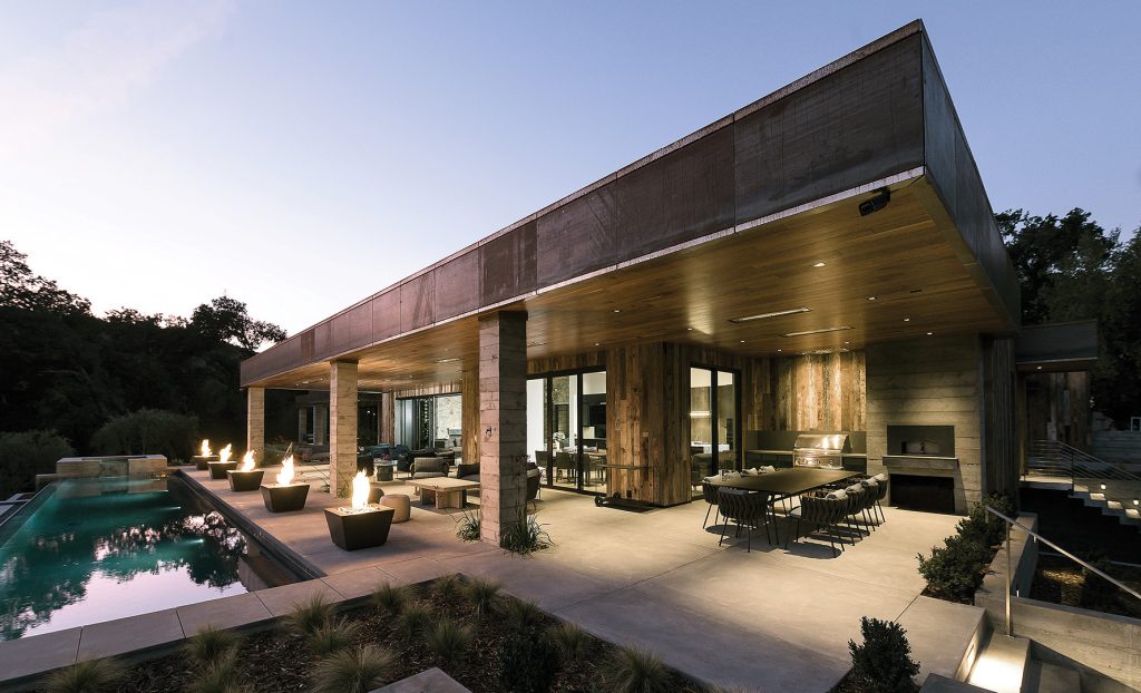Example of a huge minimalist backyard concrete patio kitchen design in San Francisco with a roof extension
