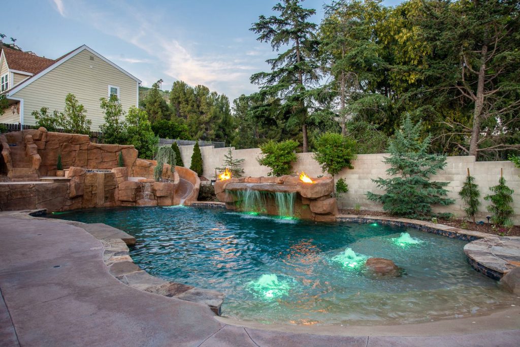 Example of a huge mountain style backyard concrete and custom-shaped natural pool fountain design in Orange County