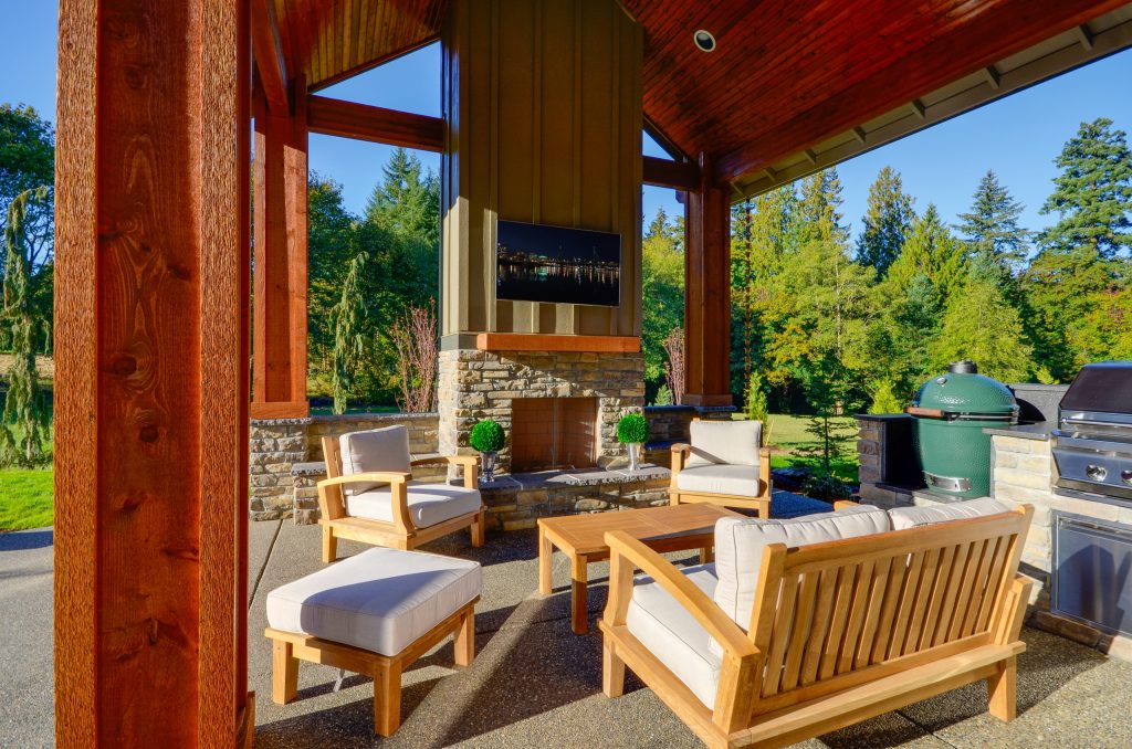 Example of a large arts and crafts backyard concrete patio kitchen design in Portland with a roof extension