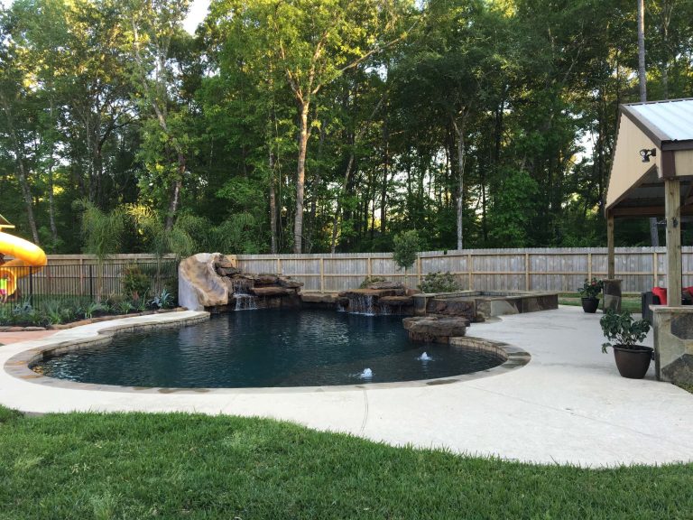 Example of a large arts and crafts backyard stone and custom-shaped lap water slide design in Houston