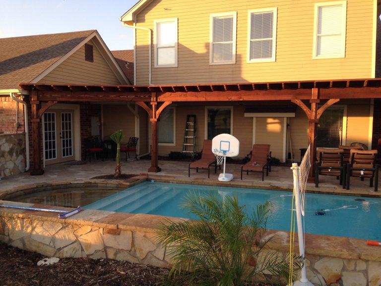 Example of a large arts and crafts backyard stone patio kitchen design in Dallas with a pergola