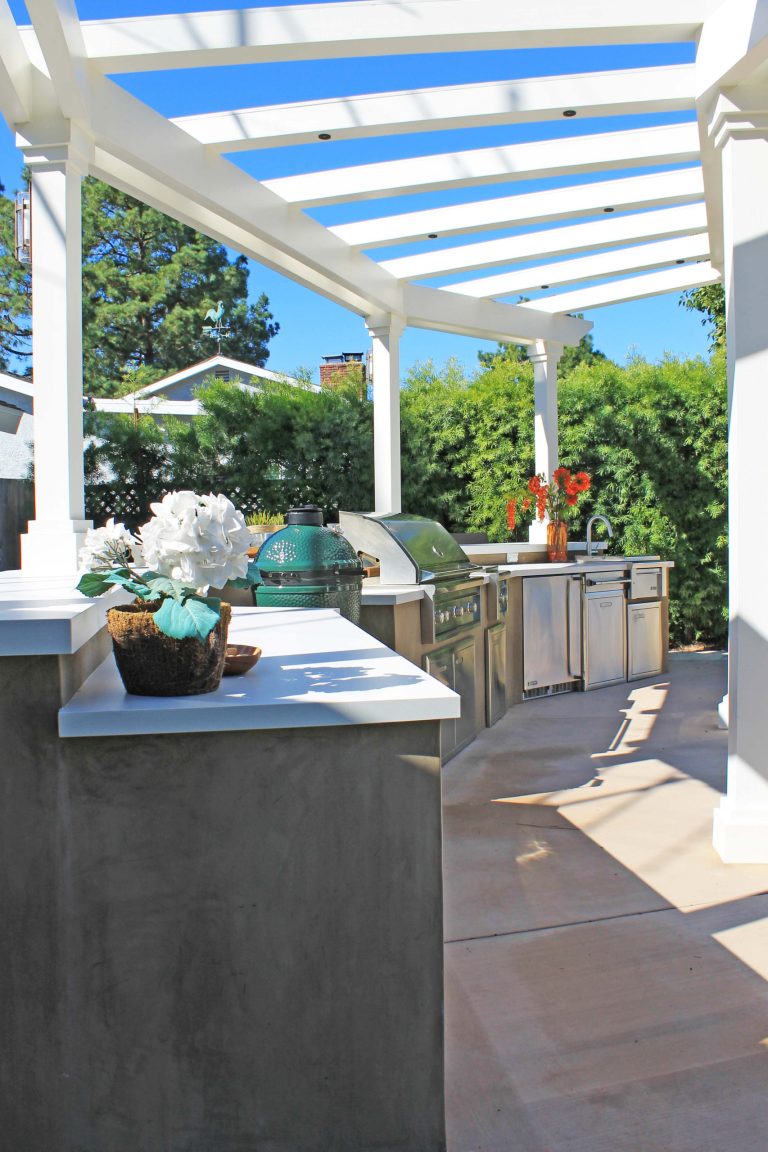 Example of a large backyard concrete paver patio kitchen design in Los Angeles with a pergola