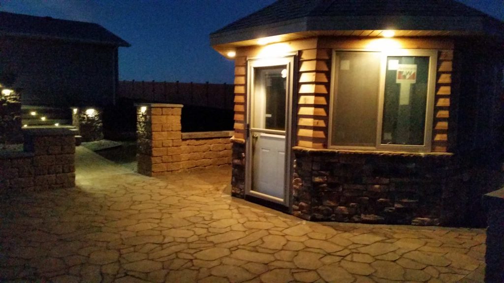 Example of a large backyard concrete paver patio kitchen design in Other with a gazebo