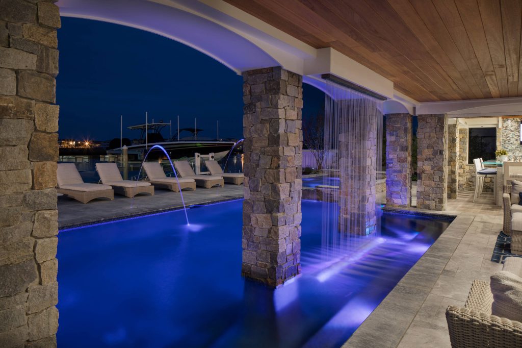 Example of a large beach style backyard concrete paver and custom-shaped lap hot tub design in Philadelphia