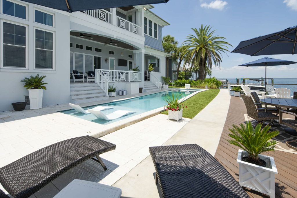 Example of a large beach style backyard concrete paver and rectangular lap hot tub design in Tampa