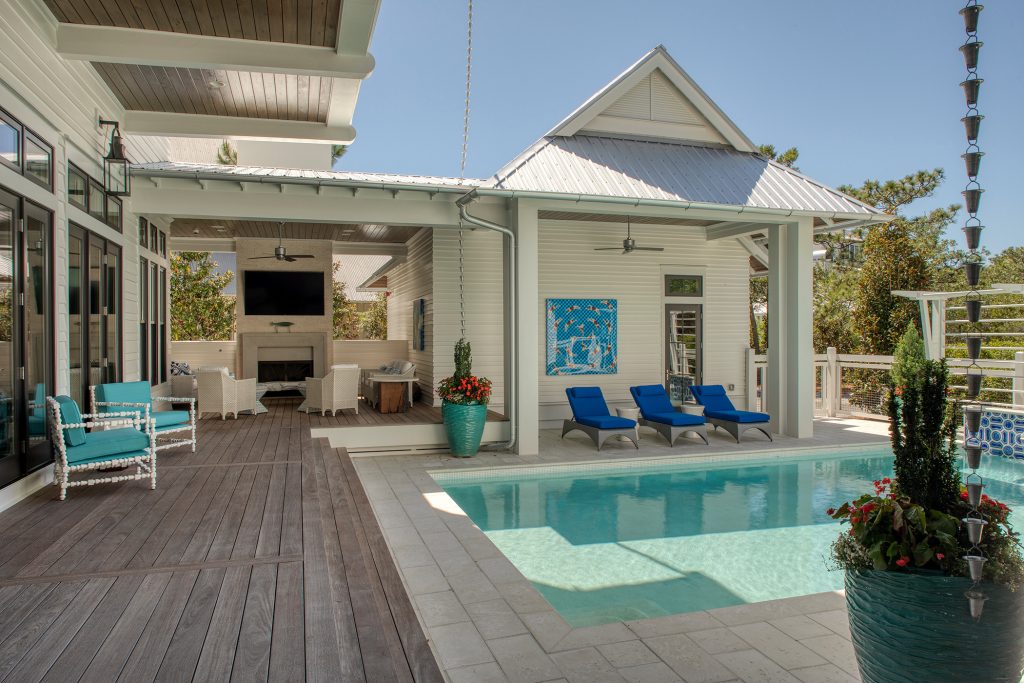 Example of a large beach style backyard concrete paver and rectangular natural pool house design in Other