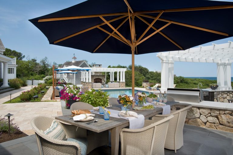 Example of a large beach style backyard tile patio kitchen design in Boston with a pergola