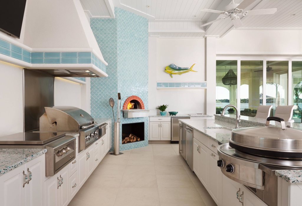 Example of a large beach style backyard tile patio kitchen design in Miami with a roof extension