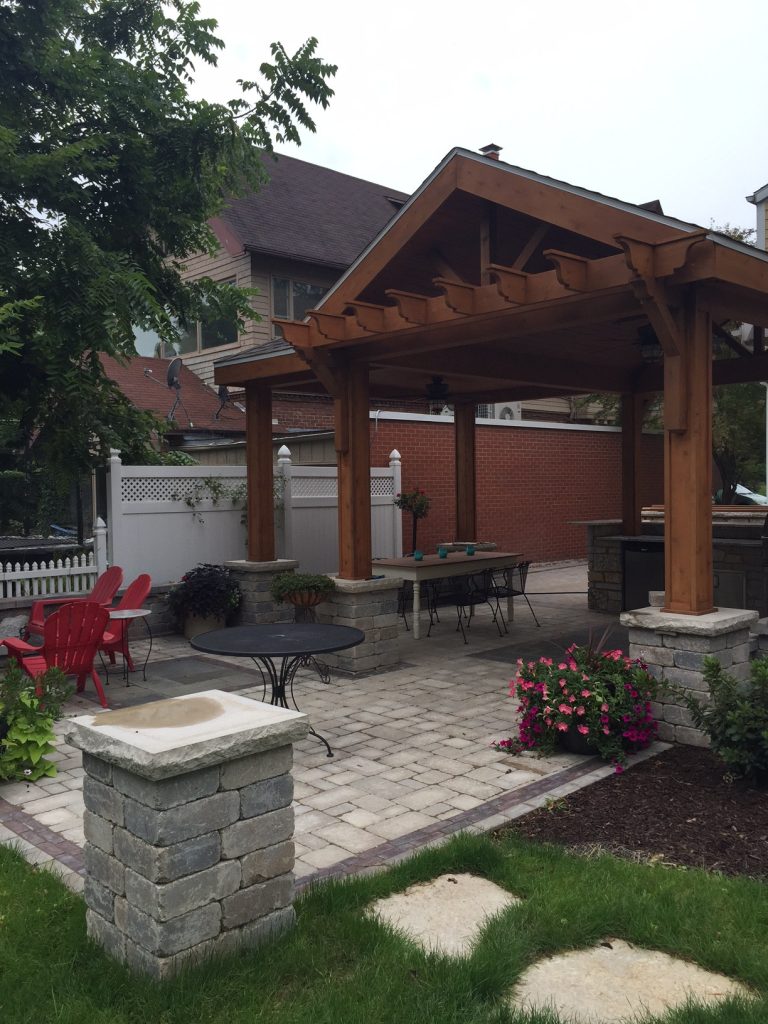 Example of a large classic backyard brick patio kitchen design in Chicago with a pergola