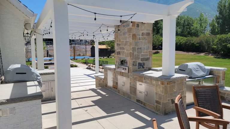 Example of a large classic backyard concrete patio kitchen design in Salt Lake City with a pergola