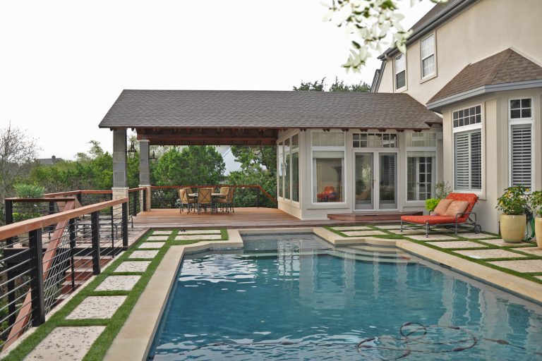 Example of a large classic backyard concrete paver and rectangular pool design in Austin