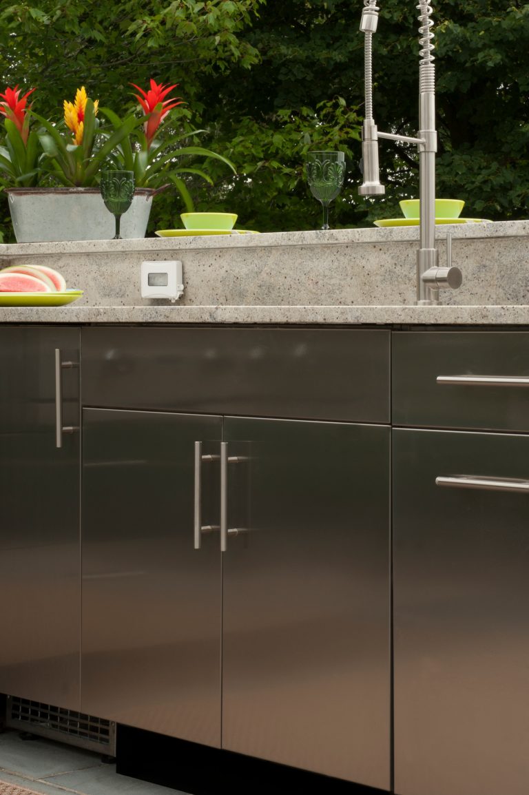Example of a large classic backyard concrete paver patio kitchen design in New York with an awning