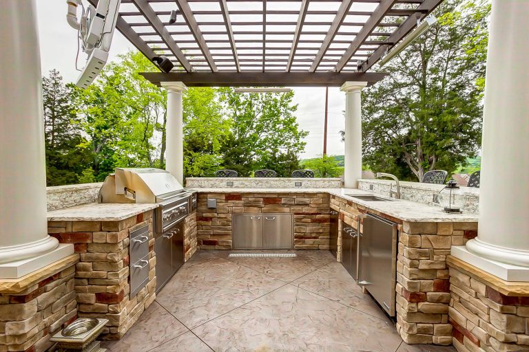 Example of a large classic backyard patio kitchen design in Nashville with a pergola