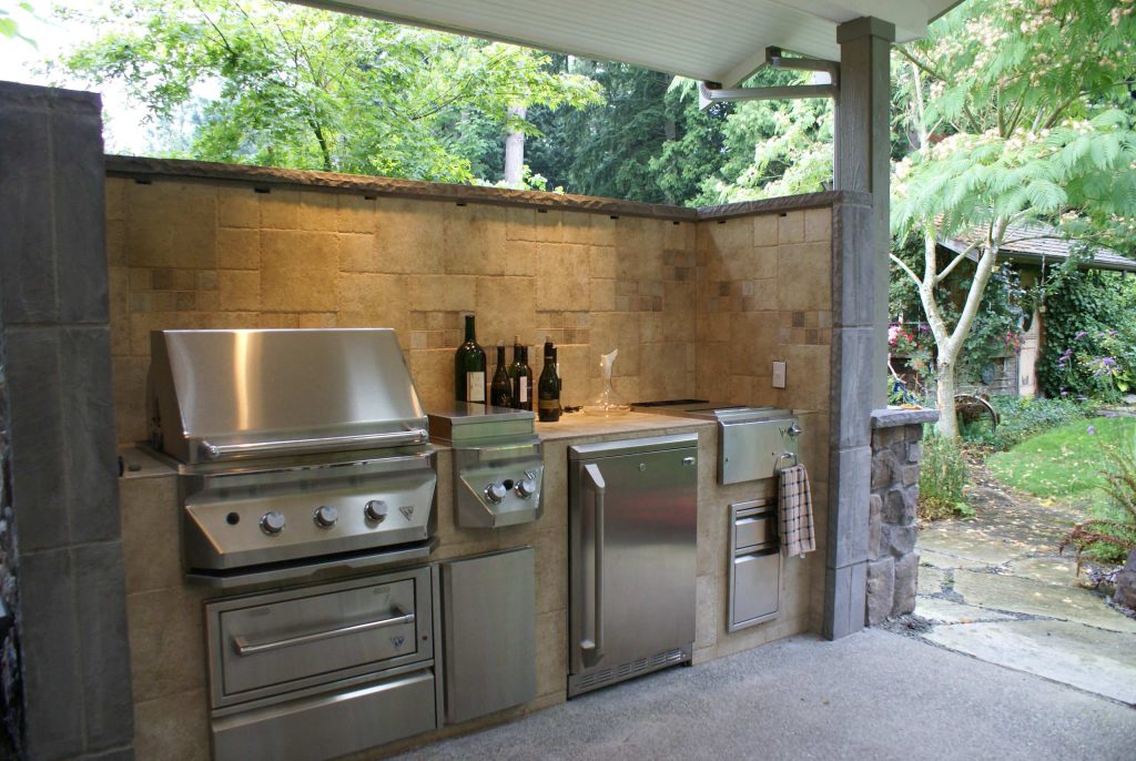 Example of a large classic backyard patio kitchen design in Seattle with a roof extension